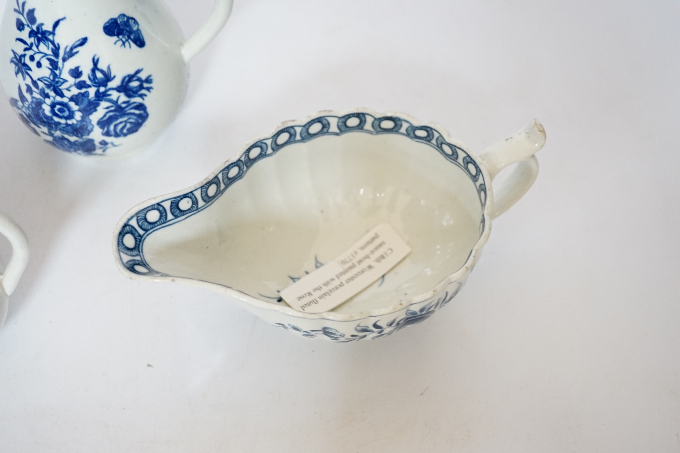 A Worcester rose pattern sauceboat c.1770 and two three flowers pattern milk jugs, largest 18cm wide